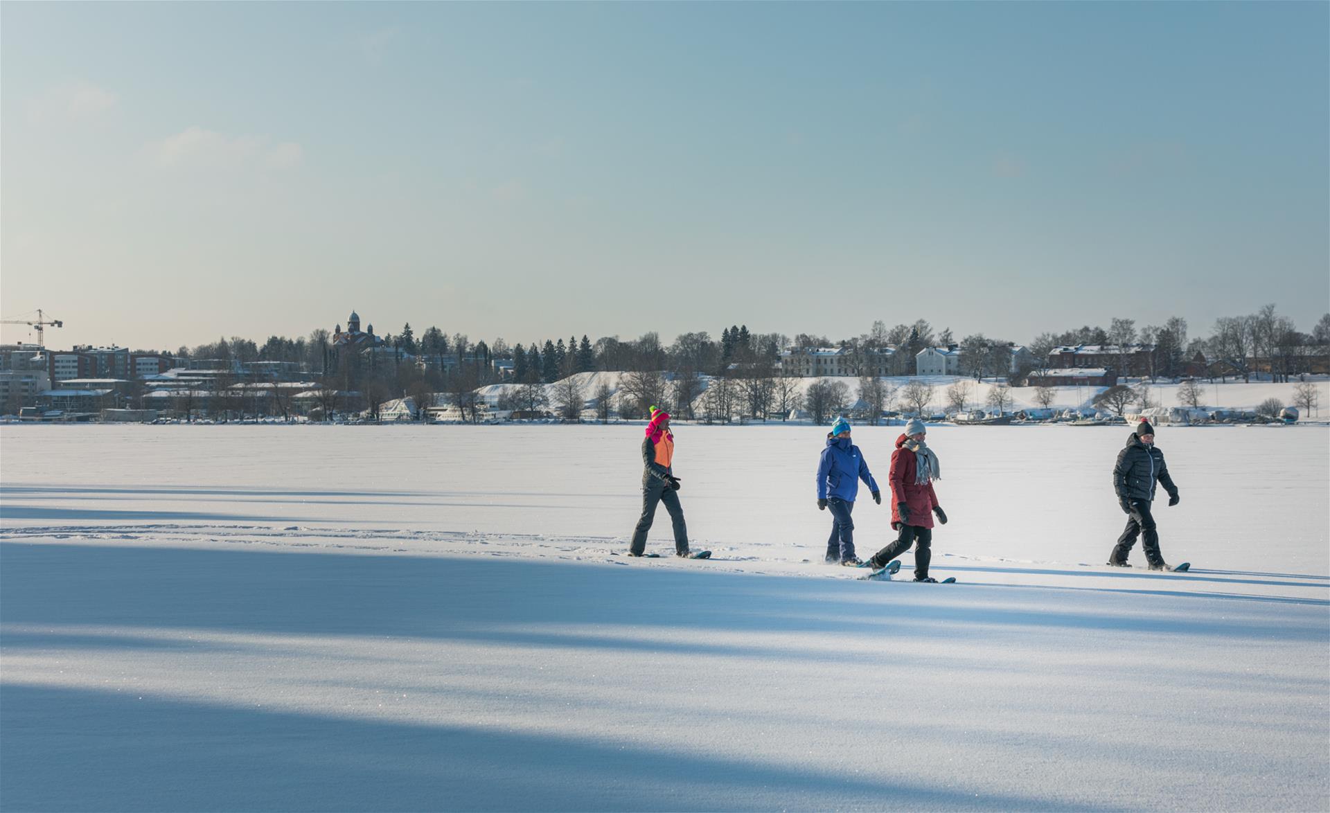 Ihmisiä kävelemässä Saimaan jäällä.